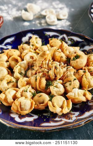 Oriental Fried Dumplings with Minced Meat also known as Gyoza, Dim Sum, Jiaozi, Momo, Tortellini, Pierogi, Varenyky, Mandu or Ravioli Close Up. Hot Crunchy Deep-Fried Beef and Mutton Pelmeni