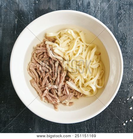 Kespe Soup, Kullama or Beshbarmak is National Central Asia Dish with a Rich Broth, Tender Veal and Homemade Noodles. Clear Bouillon with Finely Chopped Boiled Meat and Spiced Onion Sauce Top View