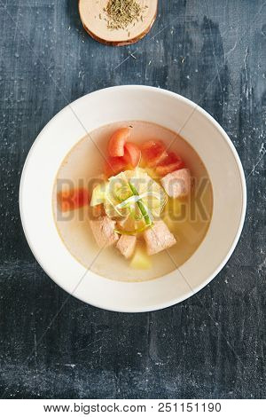 Fish Soup with Salmon, Trout or Tuna Fillet with Clear Broth, Tomatoes, Onions and Potatoes Decorated with Lemon and Greens. Fresh Hot Bouillabaisse, Cullen Skink, Ukha or Solyanka Top View