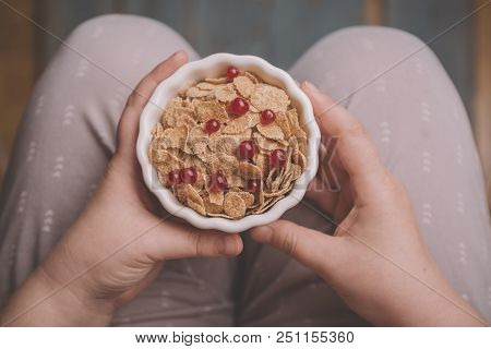 Woman Holding Bowl Of Tasty Cereal Corn Flakes With Red Currant Berries From Above Healthy Delecious