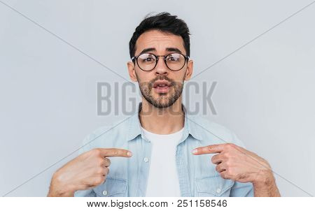 Closeup Portrait Of Handsome Bearded Young Man Points At Himself Being Puzzled To Be Chosen. Handsom