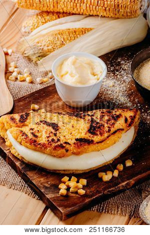 Wooden Table With Several Ingredients For The Preparation Of Cachapas With Cheese, Corn, Butter, Gro