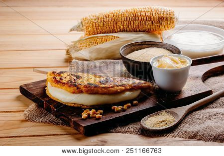 Wooden Table With Several Ingredients For The Preparation Of Cachapas With Cheese, Corn, Butter, Gro