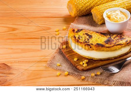 Wooden Table With Several Ingredients For The Preparation Of Cachapas With Cheese, Corn, Butter, Gro