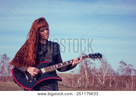 Beautiful Girl In Leather Jacket With Guitar