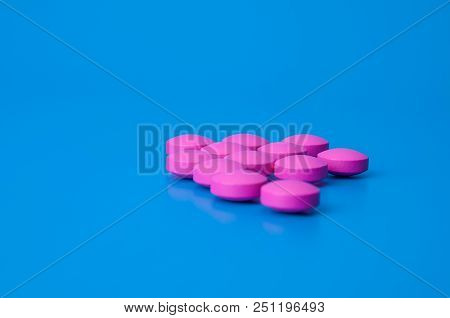 Bright Large Pink Pills On A Blue Background.