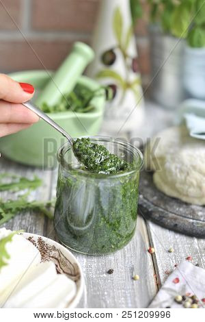 Pesto Sauce From Arugula, Dough For Pasta, On A Background Of Bricks And Mazarella.