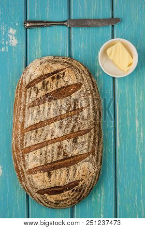 One Loaf Of Sourdough Bread On Blue Bable Board