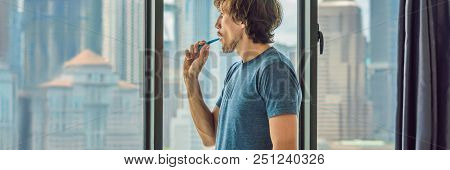Young Man Brushing His Teeth In His Bathroom. Banner, Long Format