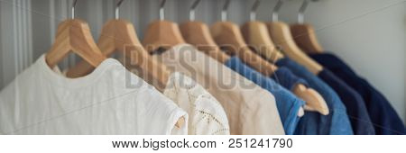 Clothes On Hangers In The Cabinet Gradient From White To Dark Blue. Banner, Long Format