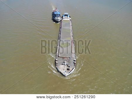 Thug Boat Maneuvers Cargo Ship On The Sava River, Belgrade, Serbia.