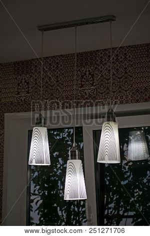 A White Decorative Lamp Hangs From The Ceiling. A Modern Chandelier In The Kitchen.