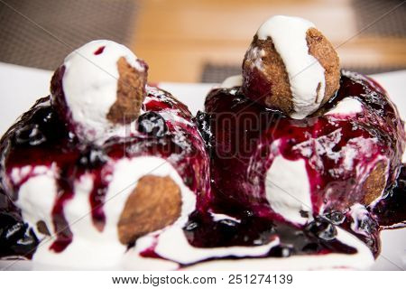 Papanasi - A Traditional Romanian Dessert. The Cake Is Made From Three Donuts Covered In Sour Cream 