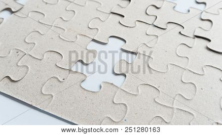 Hand Put Missing Jigsaw Puzzle Into The Paper Board