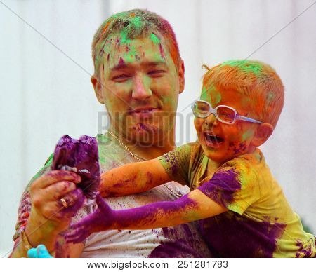 Moscow, Russia - July 14, 2018: Throwing Color At The Holi Color Festival. Happy Daddy And Son Durin
