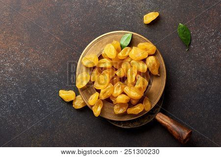 Dried Yellow Kumquat With Green Leaves On Brown Background. Top View.