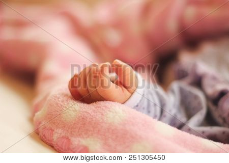 Newborn Girl Tiny Hand Over Pink Blanket