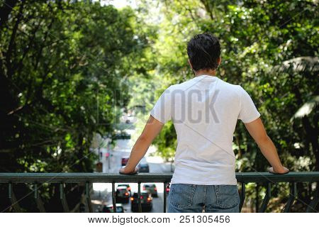 Young Man Looking At Car Traffic In The City