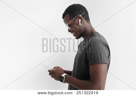 Side Portrait Of Handsome African American Man In Gray T Shirt, Isolated On Gray Background, Looking