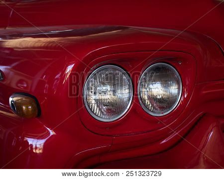 Twin Headlights On An Old Red Shiny Car
