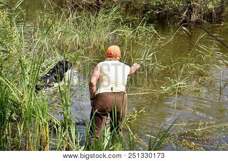 Girl Shows To The Hunting Black Labrodor Where Is The Duck In The River.