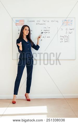 Female Teacher Giving A Lecture Showing Presentation On Whiteboard.