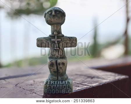 Idol Of Pomos, Ancient Symbol Of Fertility On Cyprus. A Small Sculpture On A Blurred Background. Tra