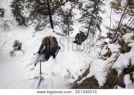 Poland, Tatra Mountains, 03.11.2017,  Guy And A Girl Climb To A Snow-covered Rock Mountain, Holding 