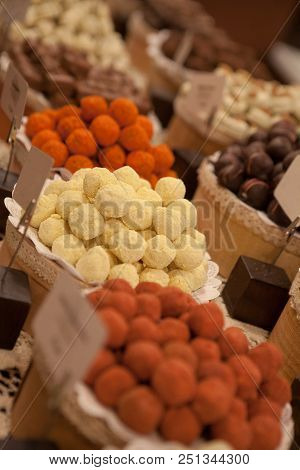 Asorted Chocolate Truffles And Pralines. Chocolate And Coconut Candies On The Counter In The Confect