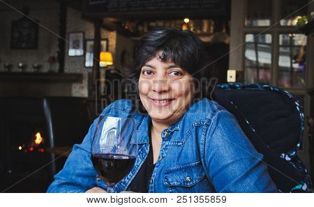 Woman Drinking Red Wine In A Gastro-pub Bar / Restaurant