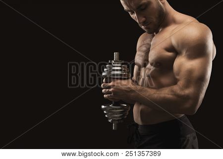 Athletic Young Man With Dumbbell On Black Background, Making Strenth Biceps Exercises. Naked Torso, 