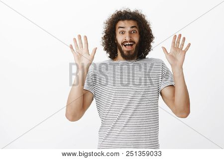 Amazed Overwhelmed Handsome Boyfriend With Afro Hairstyle And Beard, Raising Palms And Smiling Broad