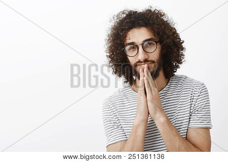 Waist-up Shot Of Handsome Dreamy Hispanic Male Model With Beard And Afro Hairstyle, Holding Hands In
