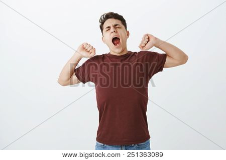 Hate Wake Up Early. Sleepy Yawning Handsome Guy In Red Shirt, Stratching And Tilting Head With Close