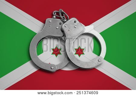 Burundi Flag  And Police Handcuffs. The Concept Of Observance Of The Law In The Country And Protecti