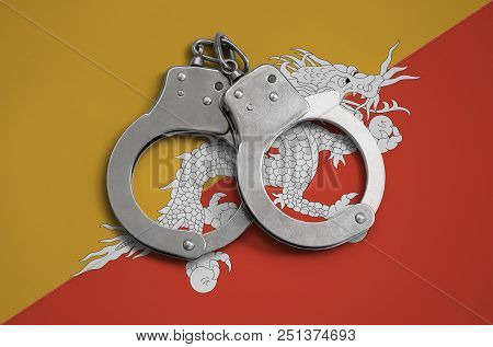 Bhutan Flag  And Police Handcuffs. The Concept Of Observance Of The Law In The Country And Protectio