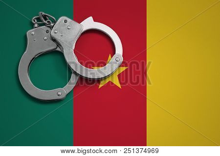Cameroon Flag  And Police Handcuffs. The Concept Of Crime And Offenses In The Country.