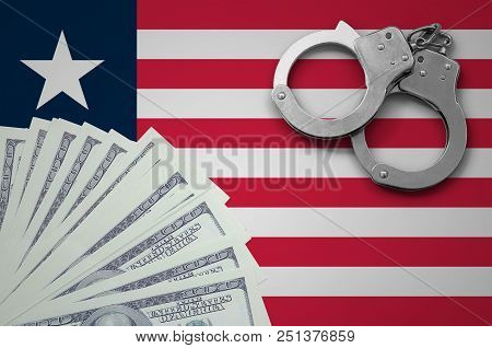 Liberia Flag  With Handcuffs And A Bundle Of Dollars. The Concept Of Illegal Banking Operations In U