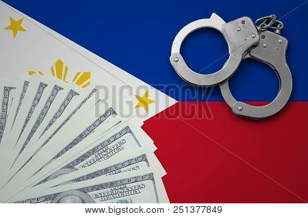 Philippines Flag  With Handcuffs And A Bundle Of Dollars. The Concept Of Illegal Banking Operations 