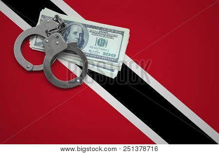 Trinidad And Tobago Flag  With Handcuffs And A Bundle Of Dollars. The Concept Of Breaking The Law An
