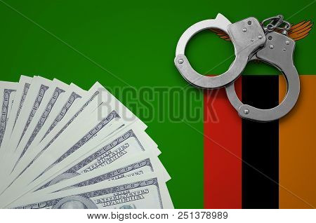Zambia Flag  With Handcuffs And A Bundle Of Dollars. The Concept Of Illegal Banking Operations In Us