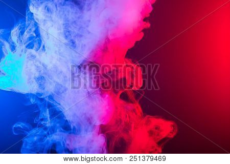 Portrait Of Asian Woman Smoking Vape Or E-cigarette In Neon Light At Black Background