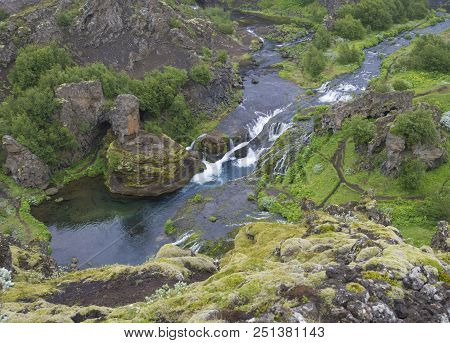 Beautiful Valley Gjain With Colorful Lava Rocks, Green Vegetation And Blue Water Stream Cascade In S