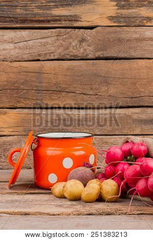Enamelware Cup And Vegetables Still Life. Wooden Desk Background.