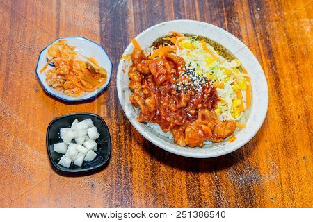 Korean Stir Fried Chicken Rice In White Bowl On Wooden Table