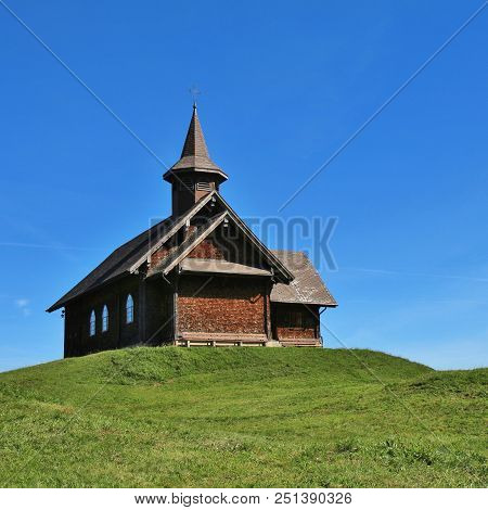 Timber Chapel On A Green Hill In Stoos, Switzerland.