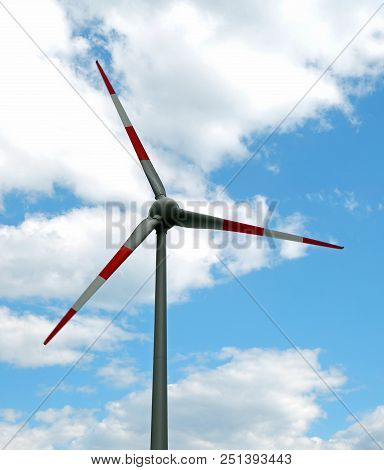 Big Red And White Wind Shovel In The Blue Sky With Clouds