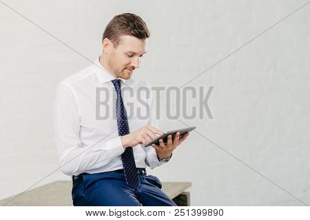 Horizontal Shot Of Successful Young Businessman Updates Profile On Business Webblog Uses Application