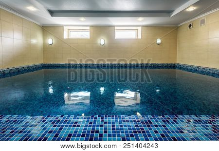 Swimming Pool In Hotel Or Residential House. Modern Pool Interior With Blue Tiles Finish. Large Empt