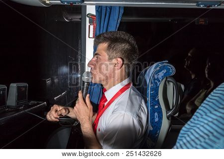 Marmaris, Turkey - May 19, 2018: Male Tour Guide With A Microphone In The Bus In Evening Time